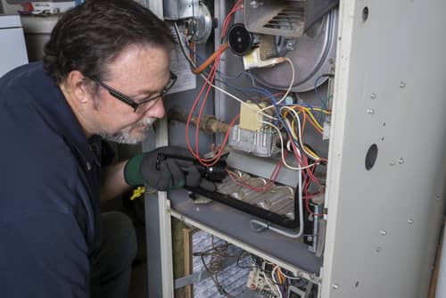 Picture of a hvac technician putting the finishing touches on an install